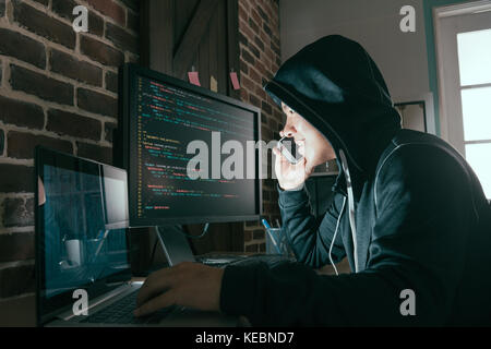 hacker using mobile smartphone calling for victim and stealing personal information through data in order to scamming ransom. Stock Photo