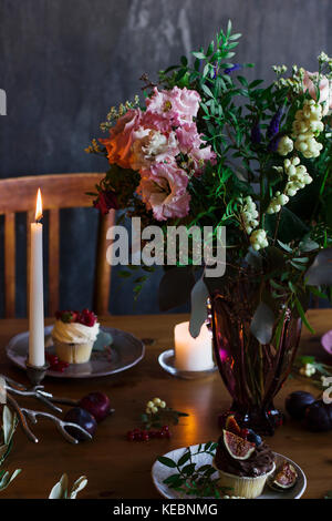 The beautiful rustic bouquet of flowers on festive table Stock Photo