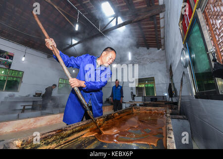 Yiwu, China's Zhejiang Province. 19th Oct, 2017. A worker stirs syrup in a brown sugar factory at Shangyang Village in Yiwu City, east China's Zhejiang Province, Oct. 19, 2017. Local villagers in Yiwu produce brown sugar productions from late October to the end of December through their traditional method, which has a history of over 300 years. Credit: Xu Yu/Xinhua/Alamy Live News Stock Photo