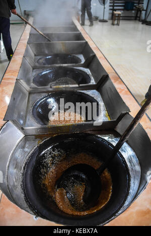 Yiwu, China's Zhejiang Province. 19th Oct, 2017. Workers boil syrup in a brown sugar factory at Shangyang Village in Yiwu City, east China's Zhejiang Province, Oct. 19, 2017. Local villagers in Yiwu produce brown sugar productions from late October to the end of December through their traditional method, which has a history of over 300 years. Credit: Xu Yu/Xinhua/Alamy Live News Stock Photo