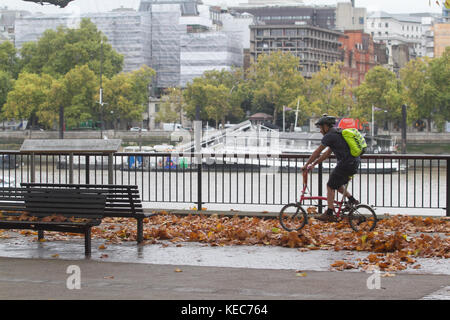 London, UK. 20th October 2017. A man cycles on the fallen leaves on London South bank on a grey autumn day Credit: amer ghazzal/Alamy Live News