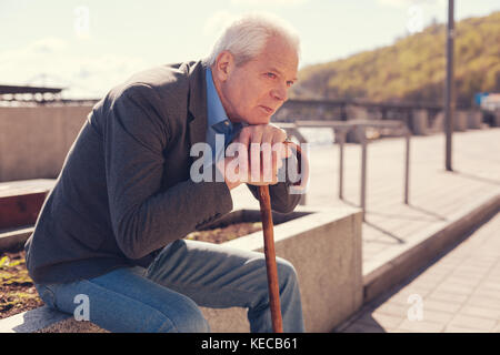 Melancholic senior man remembering his youth Stock Photo