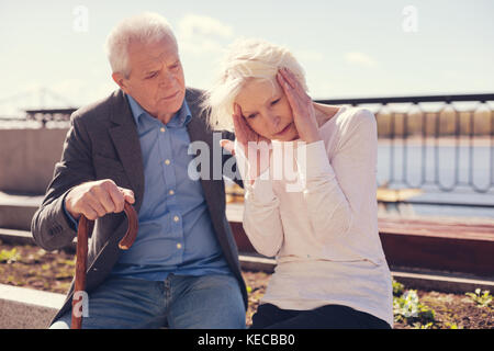 Senior man looking worriedly at his ill wife Stock Photo