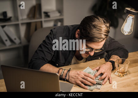 drunk man with heap of cash Stock Photo