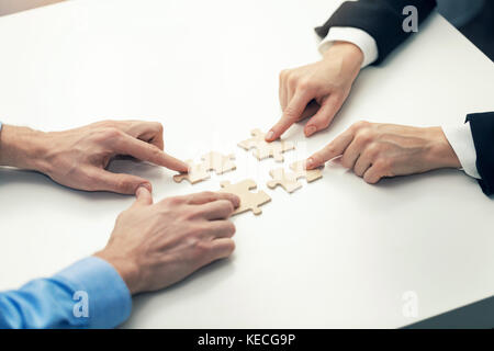 business cooperation concept - businessmen's  connecting puzzle pieces Stock Photo