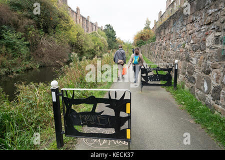 Couple walking along towpath beside the Union Canal  in Edinburgh, Scotland, United Kingdom. Stock Photo