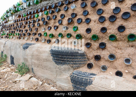 Glass bottles and used tires used in construction of earthship wall, Greater World Earthship Community, Near Taos, New Mexico, USA Stock Photo