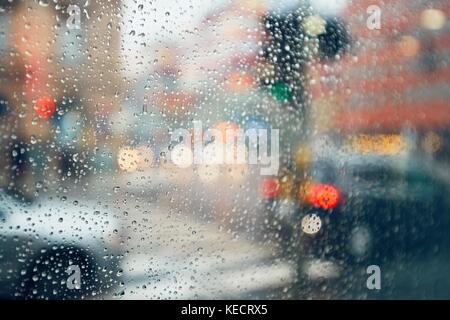 Bad weather in the city. View through drops of rain on the window. Stock Photo