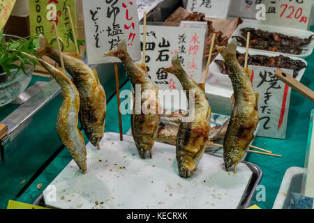 Kyoto, Japan -  May 22, 2017: Baked fishes on a stick as a snack at the Nishiki market in kyoto Stock Photo