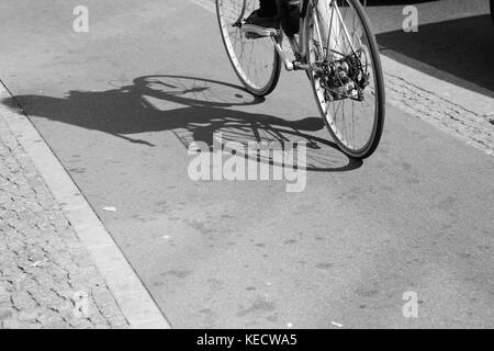 cyclist silhouette and shadow on bike lane Stock Photo