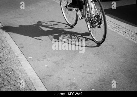 cyclist silhouette and shadow on bike lane Stock Photo