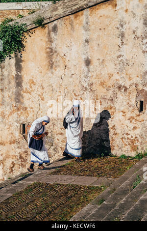 Two nuns climb a sunny staircase in Rome, Italy Stock Photo