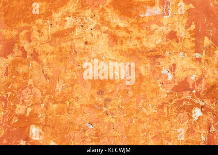 Detail from a bright orange, sunlit, very worn wall in Rome, Italy Stock Photo