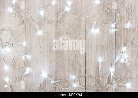 White Christmas lights frame, above view on a light gray wood background Stock Photo