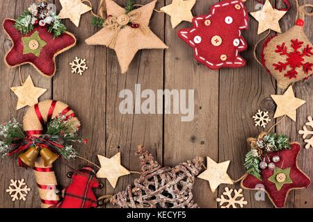 Rustic Christmas frame with burlap and cloth ornaments over an aged wood background Stock Photo