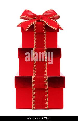 Stacked red Christmas gift boxes wrapped with rustic red bow and ribbon, isolated on white Stock Photo