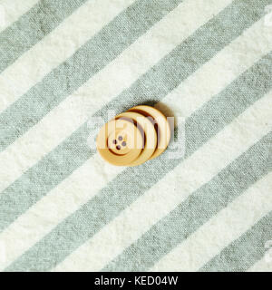 Beige simple button on stripe pattern cloth background Stock Photo