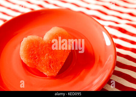 Heart shape fresh juicy watermelon on red dish Stock Photo