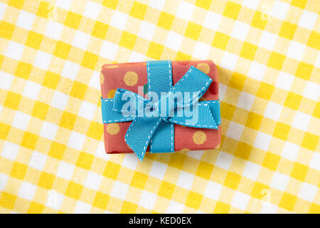 pink gift on yellow check pattern fabric background Stock Photo
