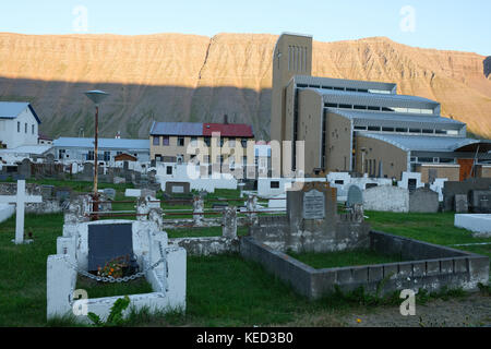 Graveyard cemetery and church with mountain backdrop in Isafjordur remote town, Westfjords, northern Iceland Stock Photo