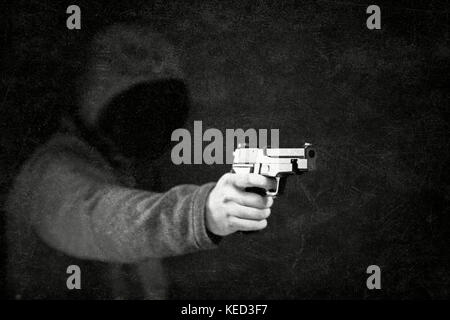 Ghostly figure with a gun in the dark Stock Photo