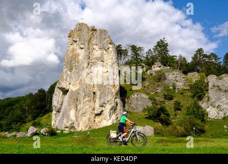 Cyclist in front of climbing rock Burgstein, near Dollnstein, Altmühltal, Upper Bavaria, Bavaria, Germany Stock Photo