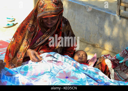 A woman makes Nakshi Kantha, a type of embroidered quilt at a village in Jessore. Bangladesh. Stock Photo