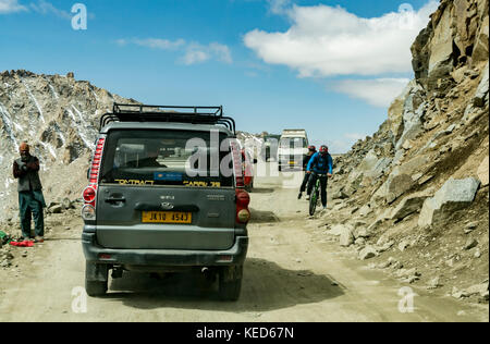 Cyclists and workers mingle on the highest navigable road at Khardungla Top, Ladakh, India at 18380 feet above sea level Stock Photo