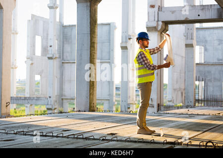 Picture of construction site engineer looking at plan Stock Photo