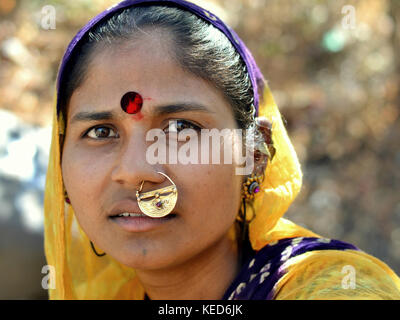 Head shot of a young Gujarati woman with yellow dupatta and precious traditional Indian nose jewellery Stock Photo