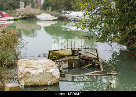 A small pleasure boat abandoned and sinking on a river in the UK. Stock Photo