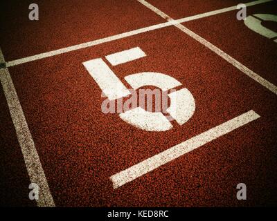 Number five. Big white track number on red rubber racetrack. Gentle ...