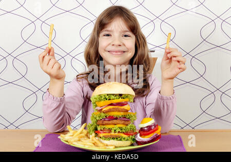 little girl with big hamburger and french fries Stock Photo