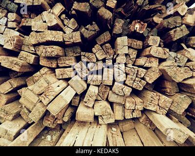 Terrible smell pile of extracted old wooden ties. Old oiled used oak railway sleepers stored after big reconstruction of old railway station. Stock Photo