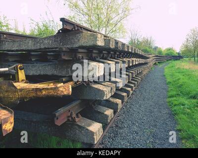 Recycling company stock. Rail platform with old concrete and wooden sleepers extracted  with rail rods waiting for transport to steel foundry for reme Stock Photo