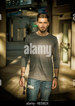 Handsome young man standing in station Stock Photo