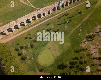 Aerial view of some people playing golf in a field near the ancient Roman Aqueduct in Rome, Italy. Stock Photo