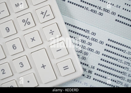 Close up of white calculator on statements background. Stock Photo