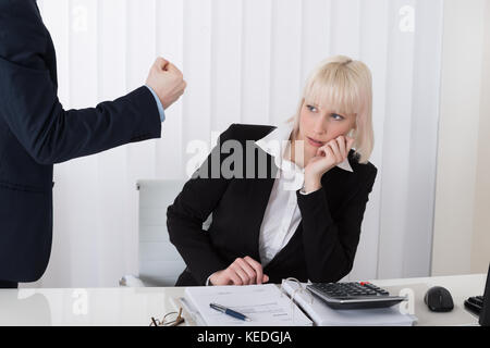 Close-up Of Boss Blaming Young Female Employee For Bad Results In Office Stock Photo