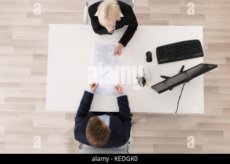 High Angle View Job Interview At Desk Stock Photo