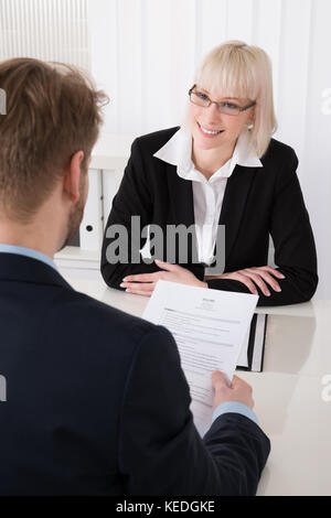 Male Manager Interviewing A Young Female Applicant In Office Stock Photo