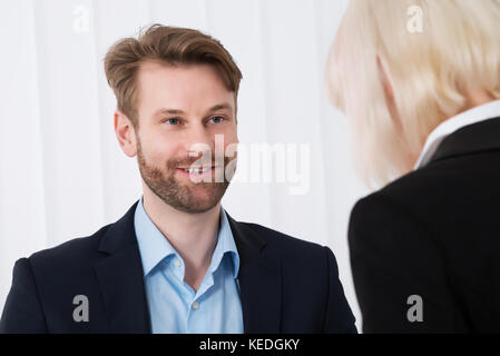 Two Young Businesspeople Having Conversation In Office Stock Photo