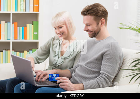 Young Happy Couple Shopping Online Using Laptop Stock Photo