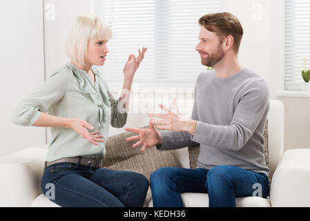 Couple Sitting On Couch Quarreling With Each Other Stock Photo