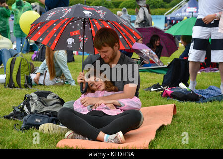 Moscow - June 04: A couple watches a concert under the rain at jazz festival on June 04, 2016 in Moscow, Russia Stock Photo