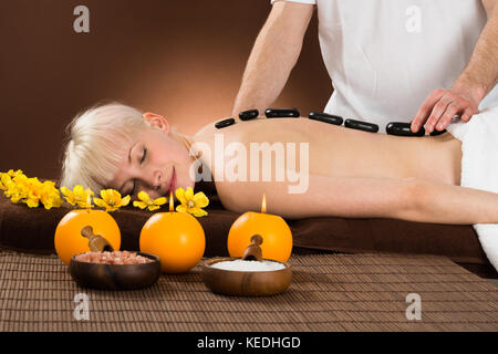 Young Woman Receiving Hot Stone Therapy In A Beauty Spa Stock Photo