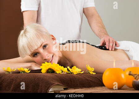 Young Woman Receiving Hot Stone Therapy In A Beauty Spa Stock Photo