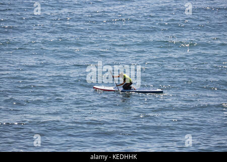 lady stand up paddle boarder kneeling paddle Stock Photo