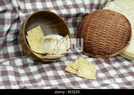 Whole grain crackers / crispy bread in wooden bowl on the table in the kitchen Stock Photo