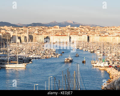 MARSEILLE, FRANCE - AUGUST 07, 2017: The old Vieux Port of Marseille beneath Cathedral of Notre Dame, France, at sunset. Stock Photo